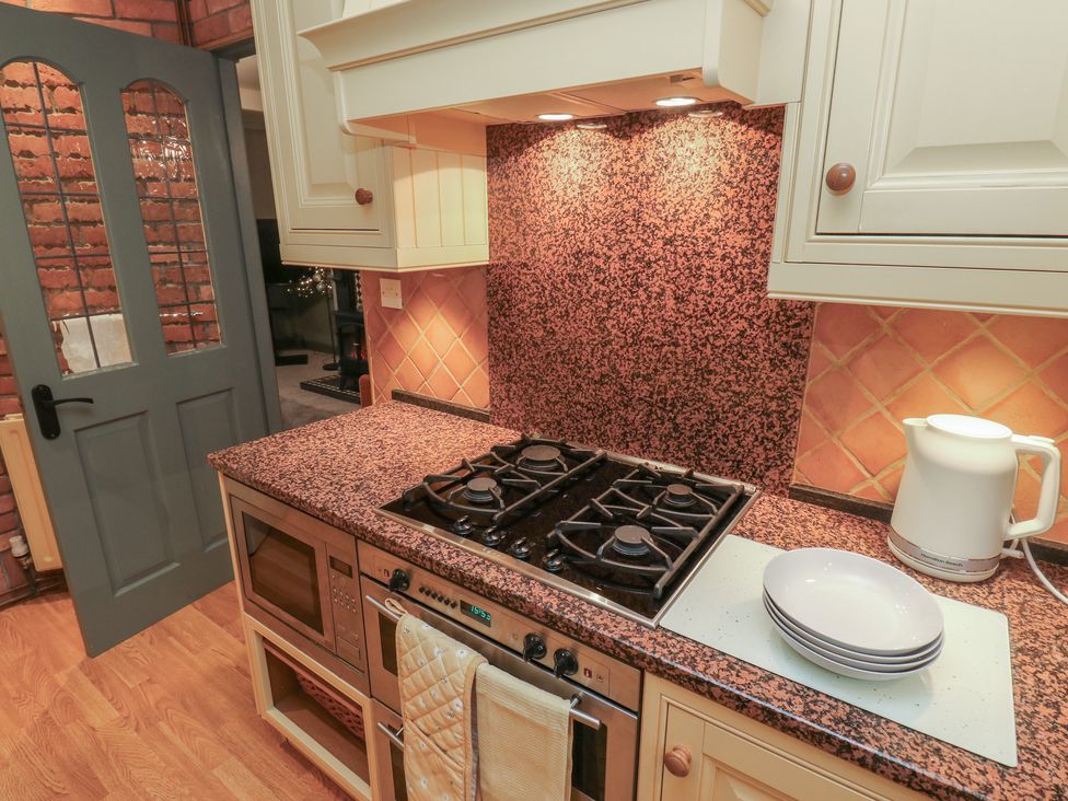 A kitchen with a gas stove and countertop at Franbols Cottage in Shelf
