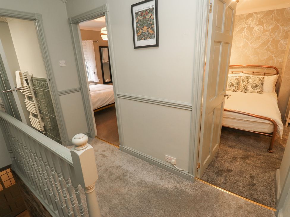 A hallway with doors to the bedroom and bathroom at Franbols Cottage in Shelf
