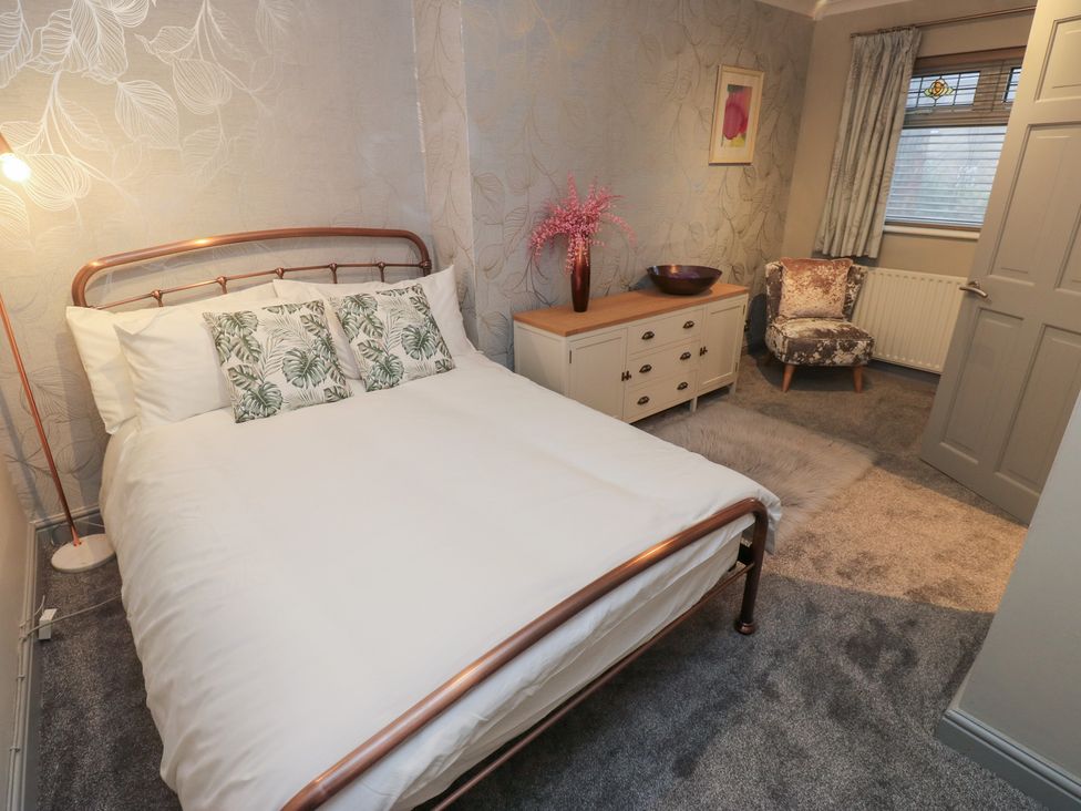 A bedroom with a bed, side table, and chair at Franbols Cottage in Shelf