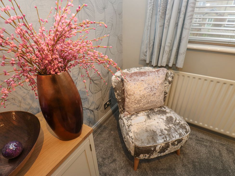 A living room featuring a flower arrangement in a vase and an armchair at Franbols Cottage in Shelf
