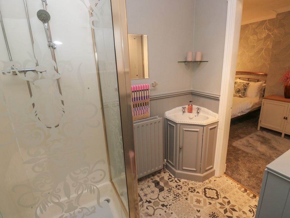 A bathroom featuring a shower, wash basin, and towels at Franbols Cottage in Shelf