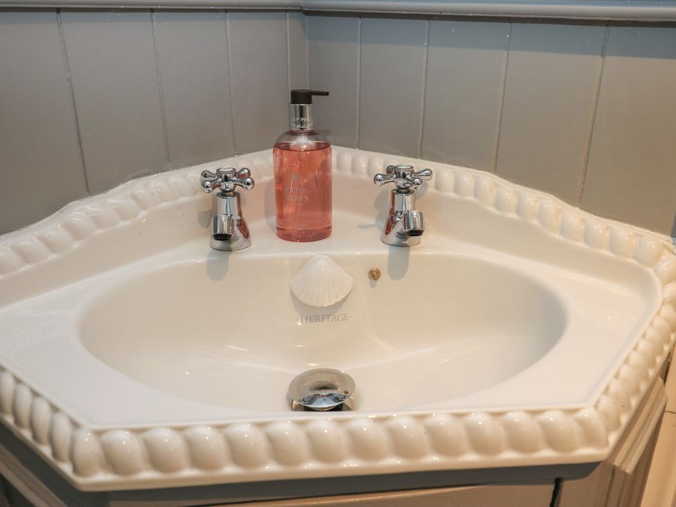 A sink with faucets and a soap dispenser at Franbols Cottage in Shelf