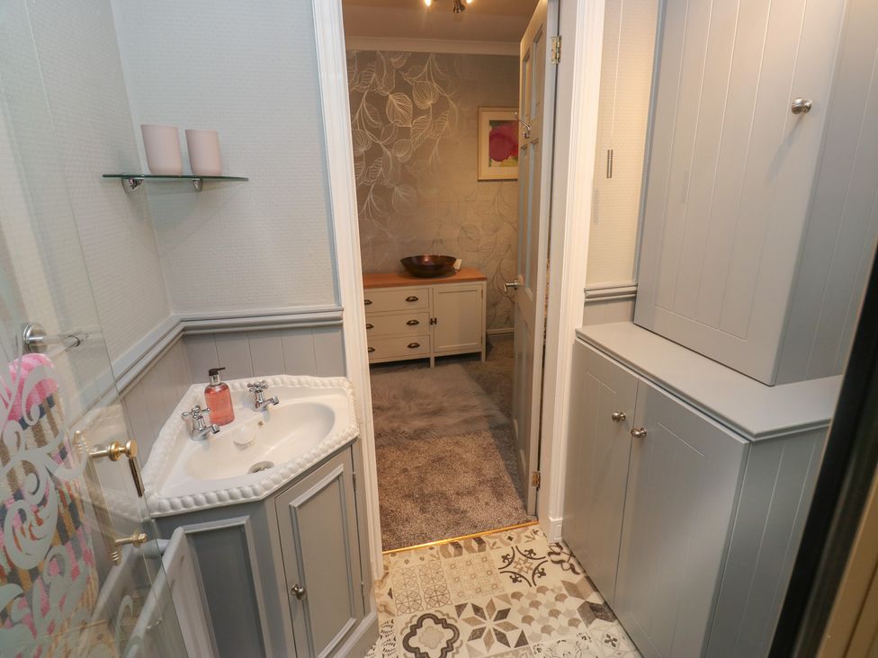 A bathroom with a sink and cabinets at Franbols Cottage in Shelf
