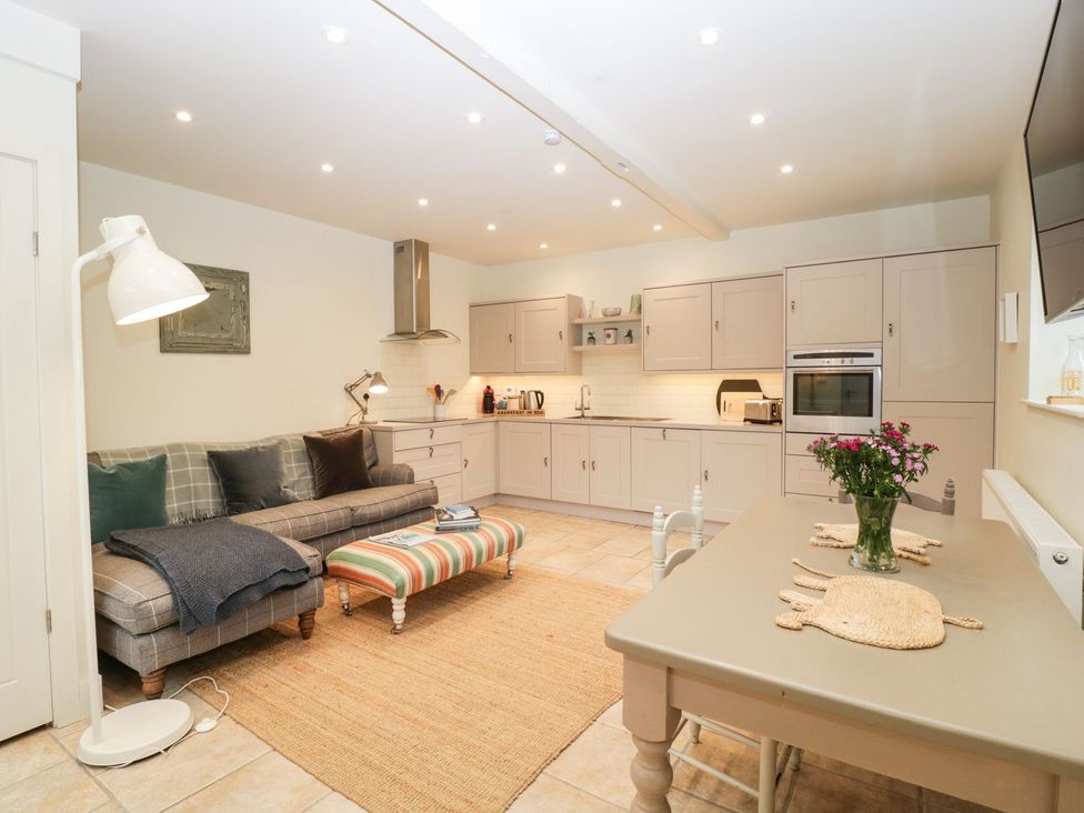 A kitchen with a sofa and dining area at The End in Langport