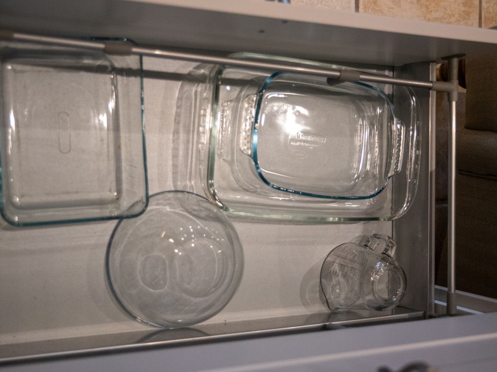 A kitchen drawer with glass containers and bowls at The End in Low Ham near Langport