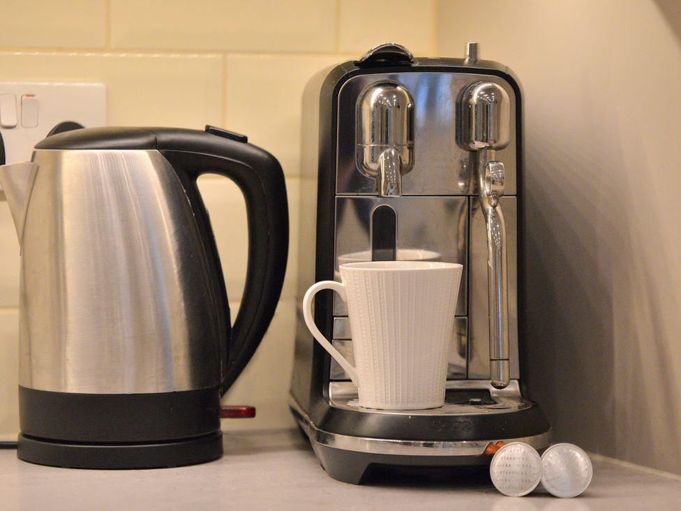 A coffee machine with a white cup and kettle on the countertop at The End in Low Ham near Langport