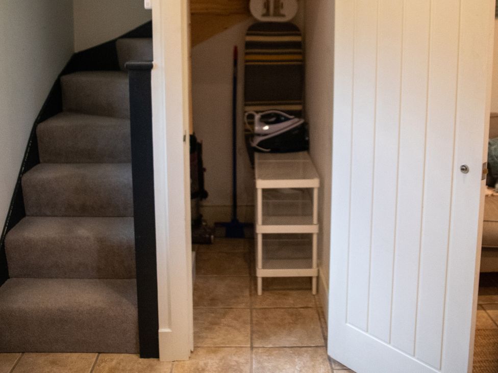 A hallway with stairs and storage at The End in Low Ham near Langport