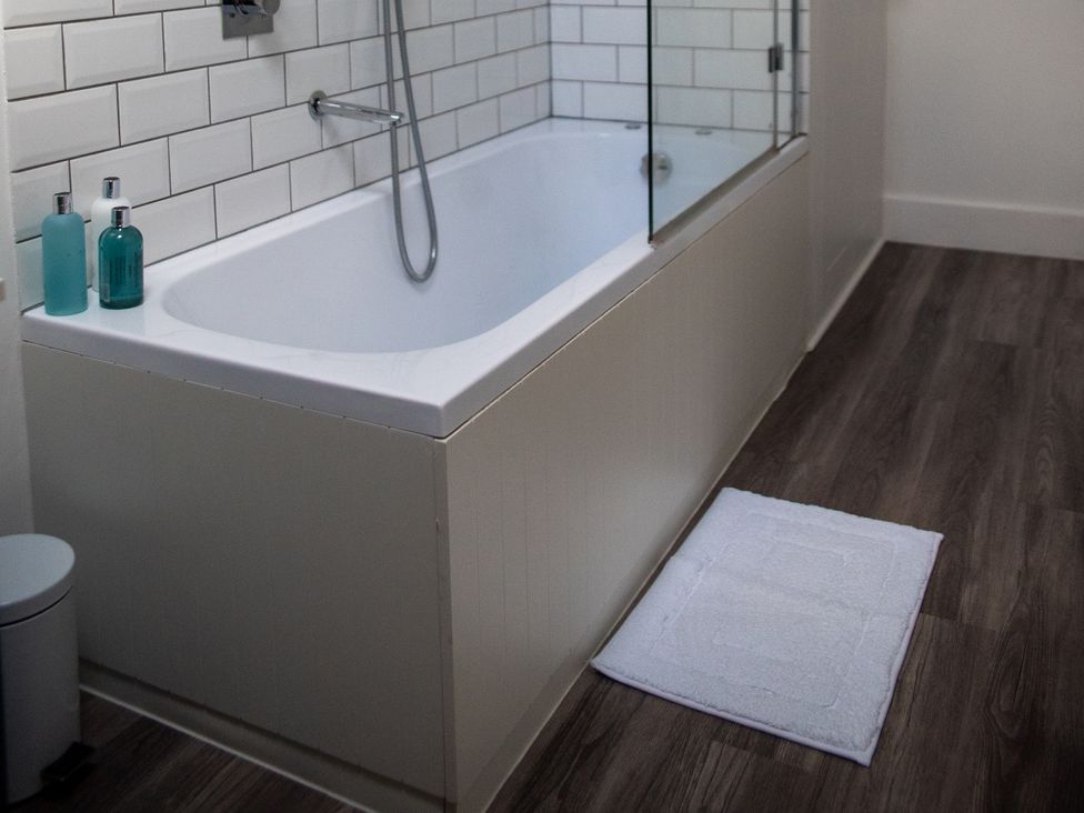 A bathroom with a bathtub and toiletries at The End in Low Ham near Langport