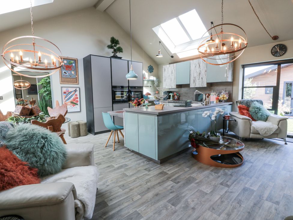 A kitchen with a sofa and dining area at Scotia At The Brig Annan