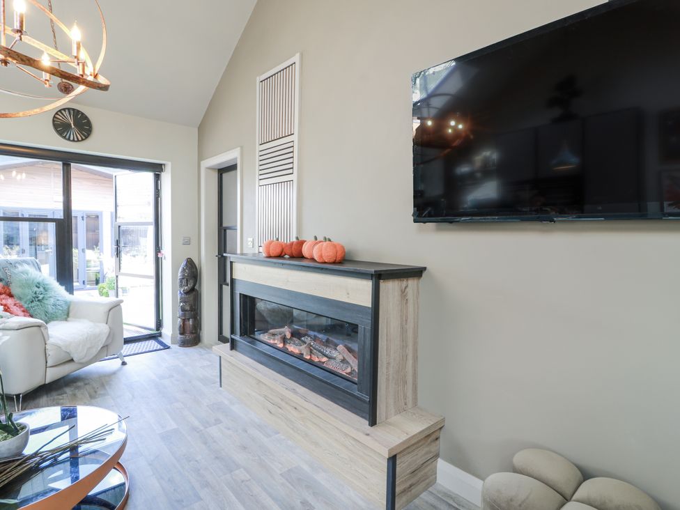 A living room with a fireplace and television at Scotia At The Brig Annan