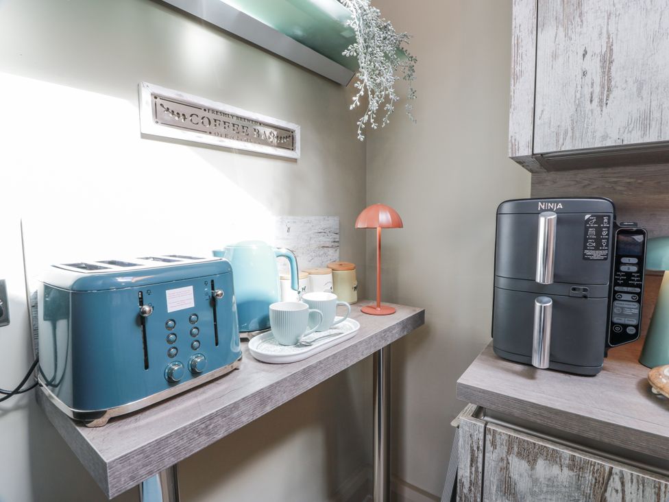 A kitchen with a toaster, kettle, and coffee maker at Scotia At The Brig Annan
