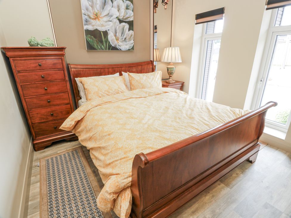 A bedroom with a bed and bedside lamp at Scotia At The Brig Annan