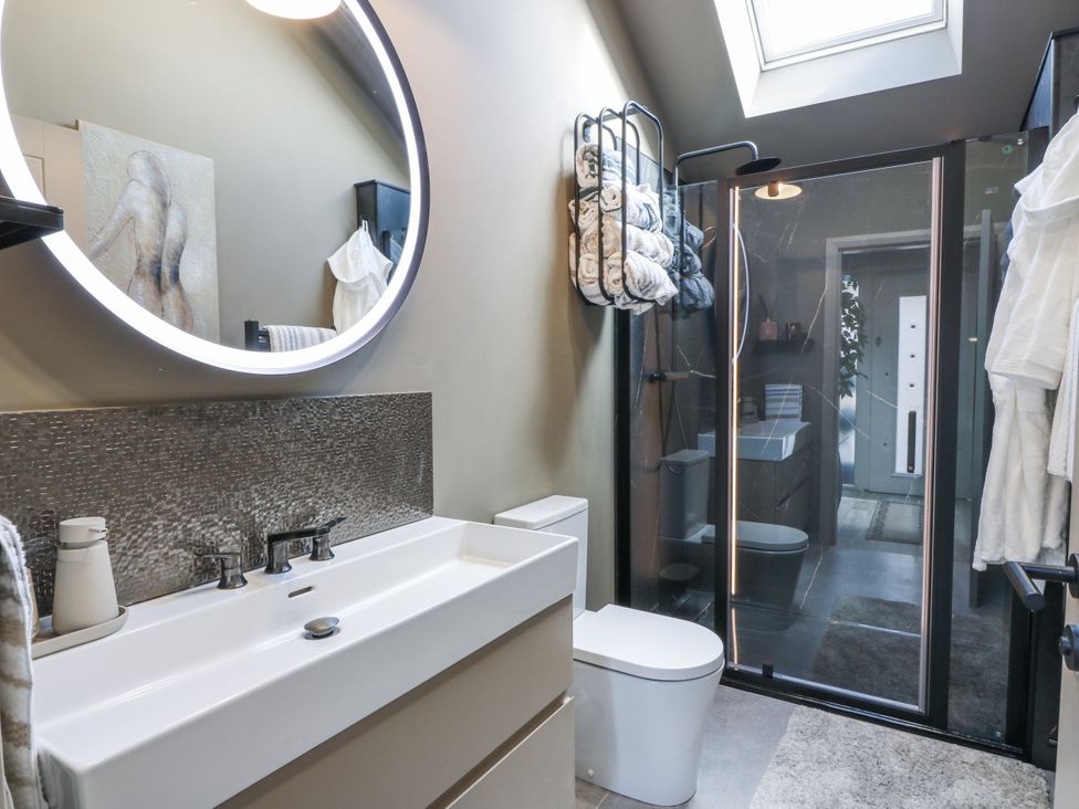 A bathroom with a sink, toilet, and shower at Scotia At The Brig Annan