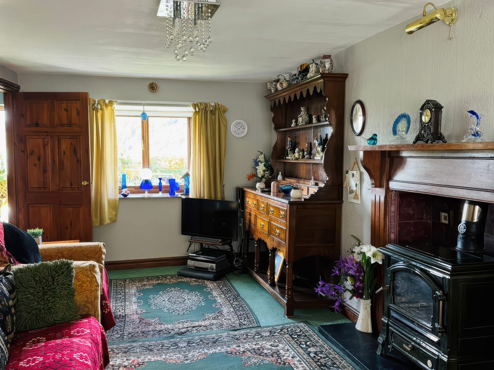 A living room with a television and decorative items at The Old Post Office in null