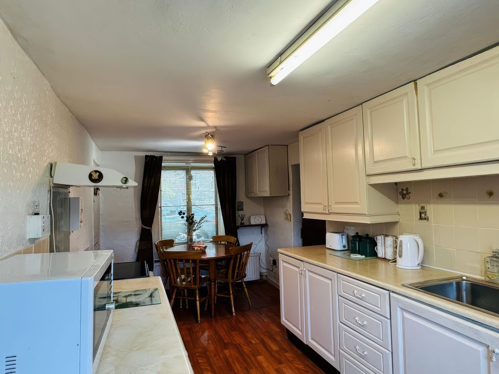 A kitchen with a table and chairs and appliances at Old Post Office in null