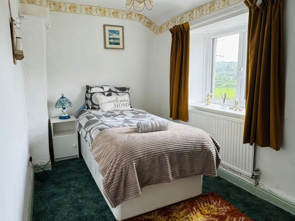 A bedroom with a bed and nightstand at The Old Post Office null