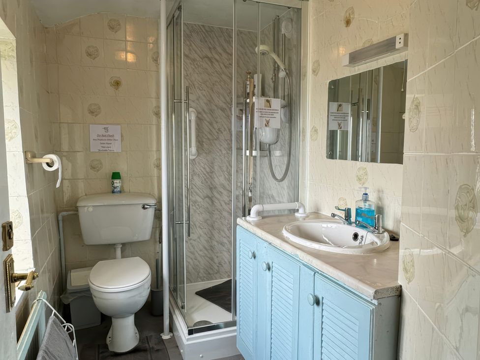 A bathroom featuring a toilet, shower unit, and sink at The Old Post Office null