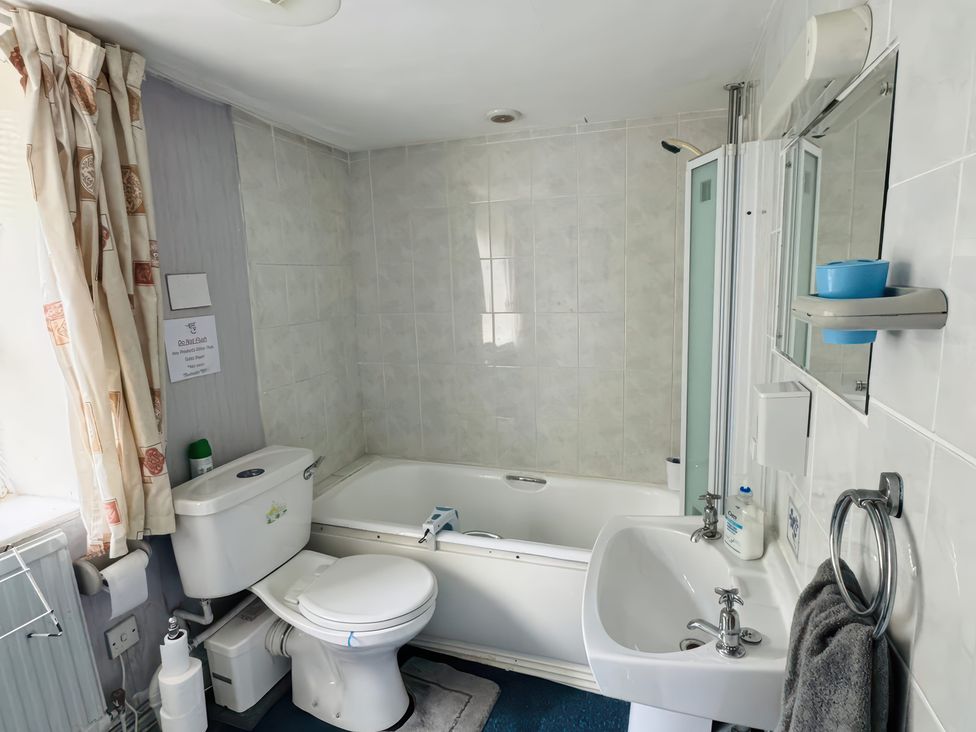 A bathroom with a bathtub, toilet, and sink at The Old Post Office in null