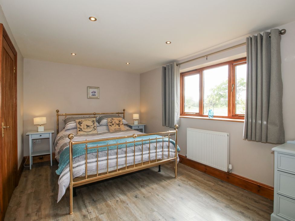 A bedroom with a bed and nightstands at Bluebell Cottage