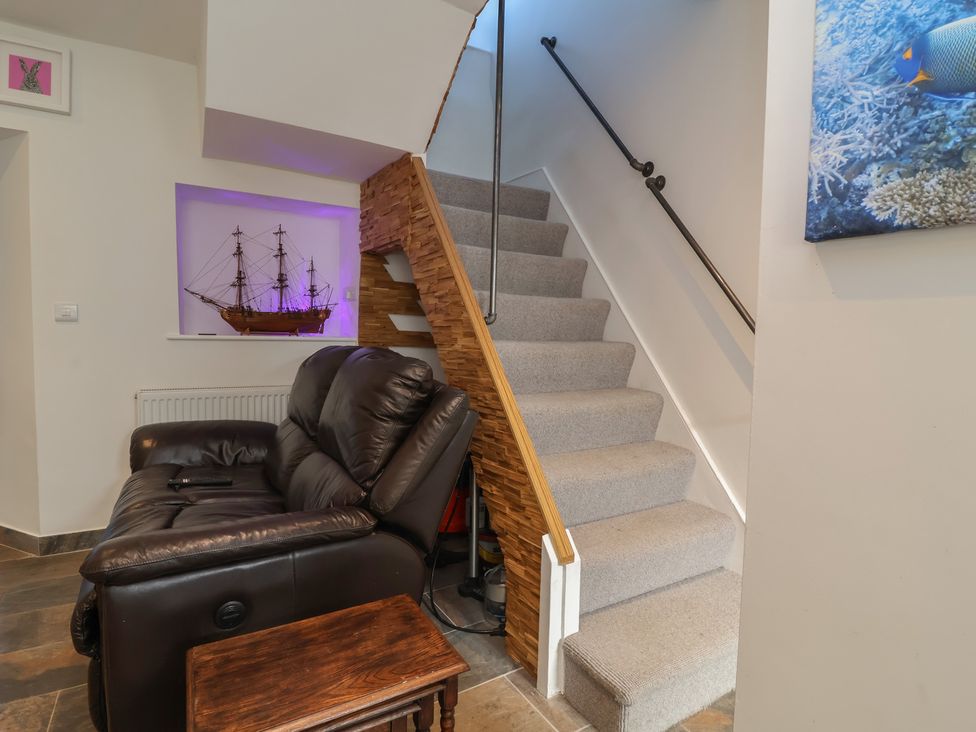 A hallway with a sofa and a staircase at Lenny's Place in Watchet