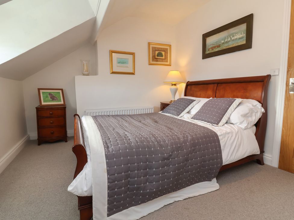 A bedroom with a bed and bedside lamp at Lenny's Place in Watchet