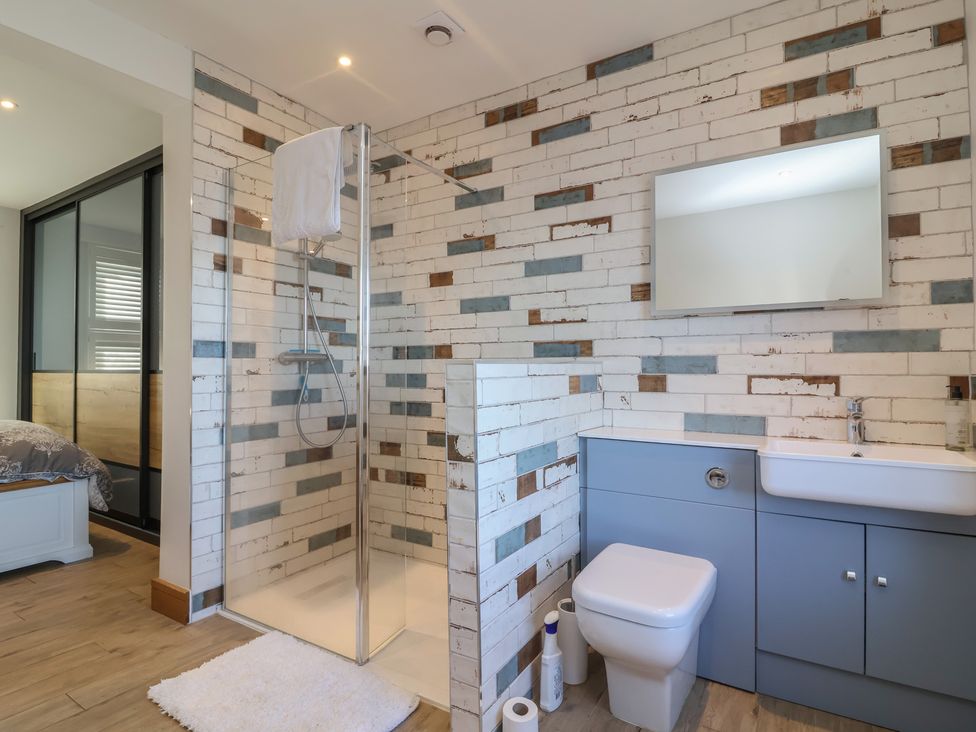 A bathroom with a shower, toilet, and sink at Lenny's Place Watchet