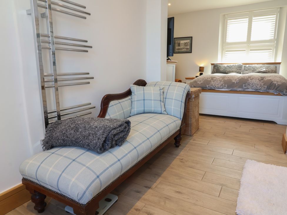 A bedroom with a bed and a sofa at Lenny's Place in Watchet