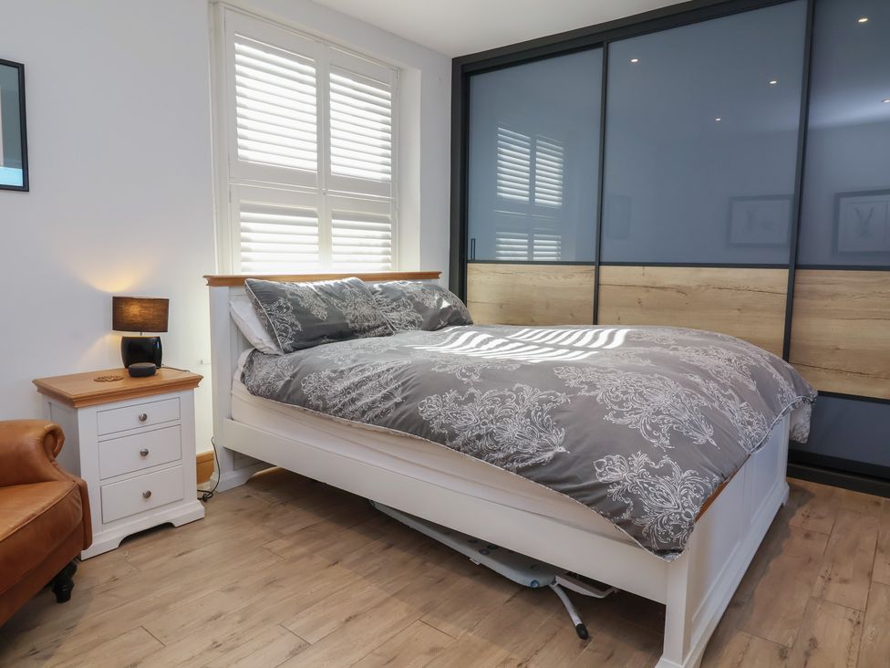 A bedroom with a bed and bedside table at Lenny's Place Watchet
