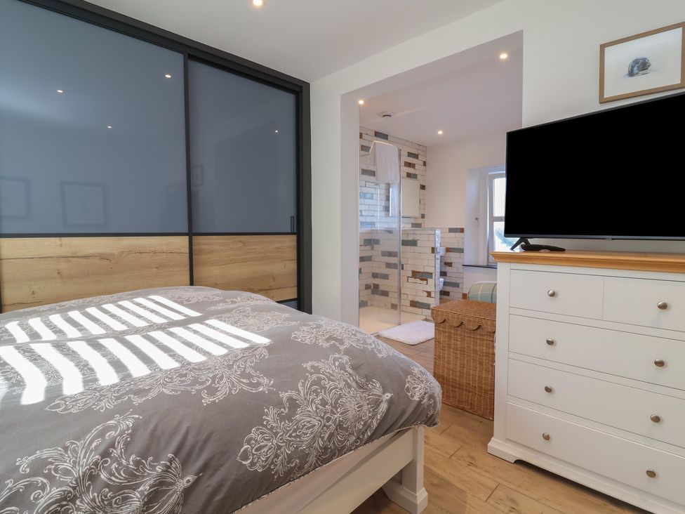 A bedroom with a bed and television at Lenny's Place in Watchet