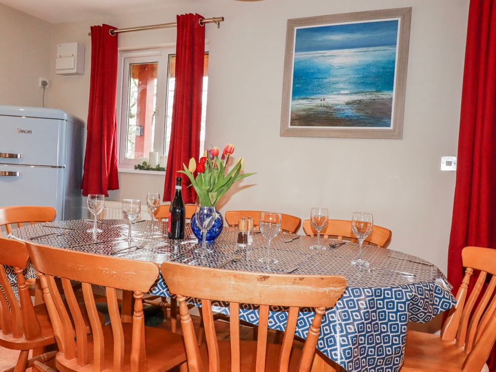 A dining room with a table set for dinner at Mayfly Lodge in St Tudy