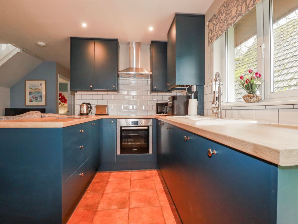 A kitchen with cabinets and an oven at Mayfly Lodge St Tudy
