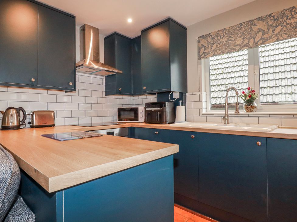 A kitchen with cabinets and appliances at Mayfly Lodge in St Tudy