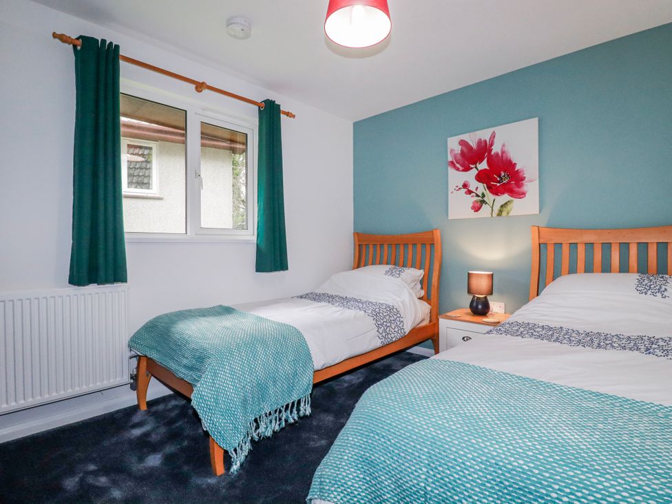 A bedroom with two beds and a window at Mayfly Lodge St Tudy