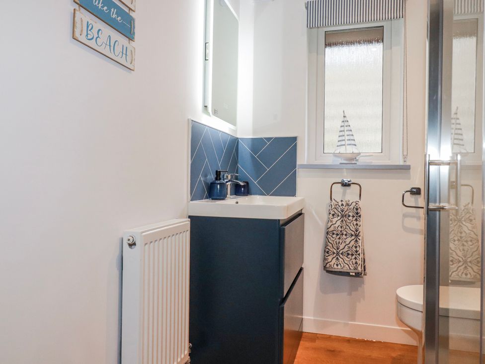A bathroom with a sink and vanity at Mayfly Lodge St Tudy