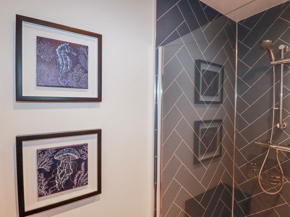 A bathroom with framed art of sea creatures at Mayfly Lodge St Tudy