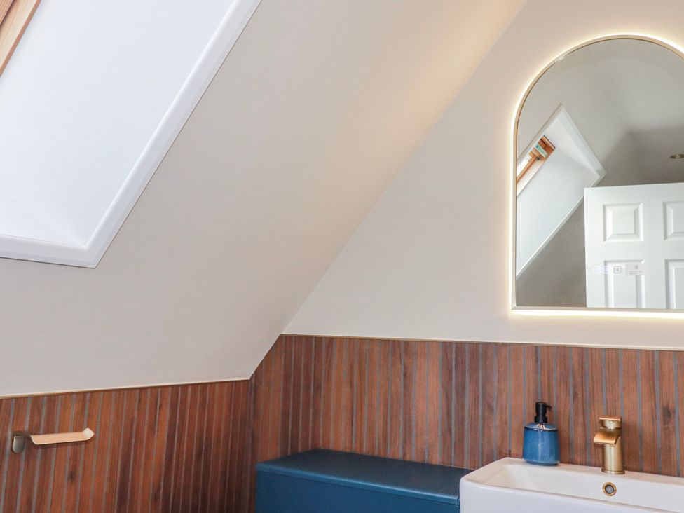A bathroom with a sink and mirror at Mayfly Lodge St Tudy