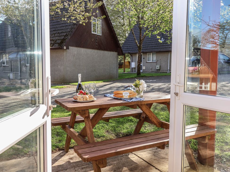 An outdoor dining area with a table set for lunch at Mayfly Lodge, St Tudy