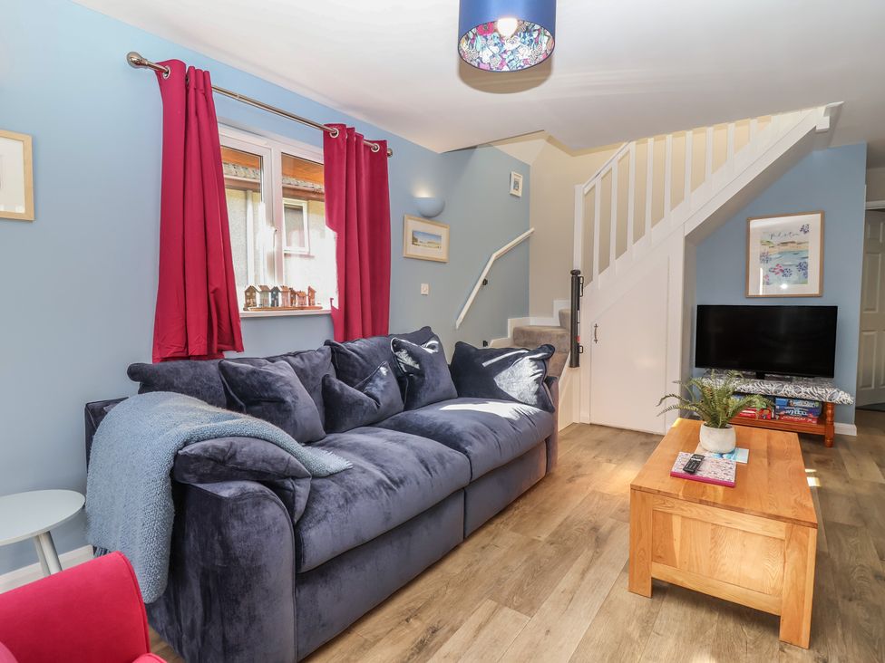 A living room with a sofa and coffee table at Mayfly Lodge in St Tudy
