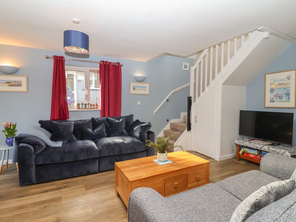 A living room with a sofa and coffee table at Mayfly Lodge in St Tudy