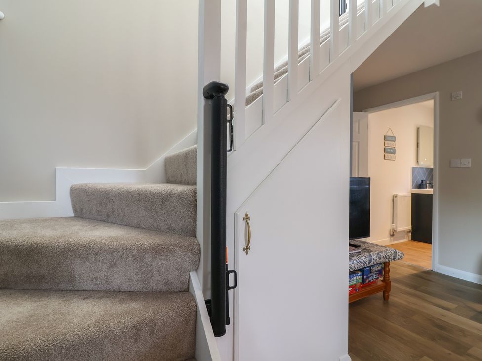 A staircase leading to the upper floor at Mayfly Lodge in St Tudy