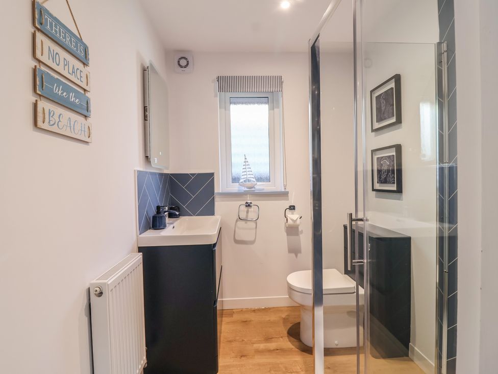 A bathroom with a wash basin and shower at Mayfly Lodge in St Tudy