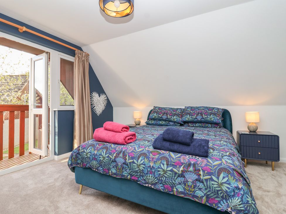 A bedroom with a bed and bedside table at Mayfly Lodge in St Tudy