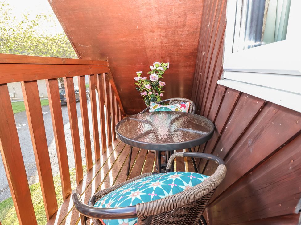 A balcony with a table and two chairs at Mayfly Lodge St Tudy
