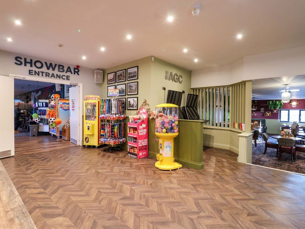 A recreation area with arcade machines and a gumball machine at Mayfly Lodge St Tudy