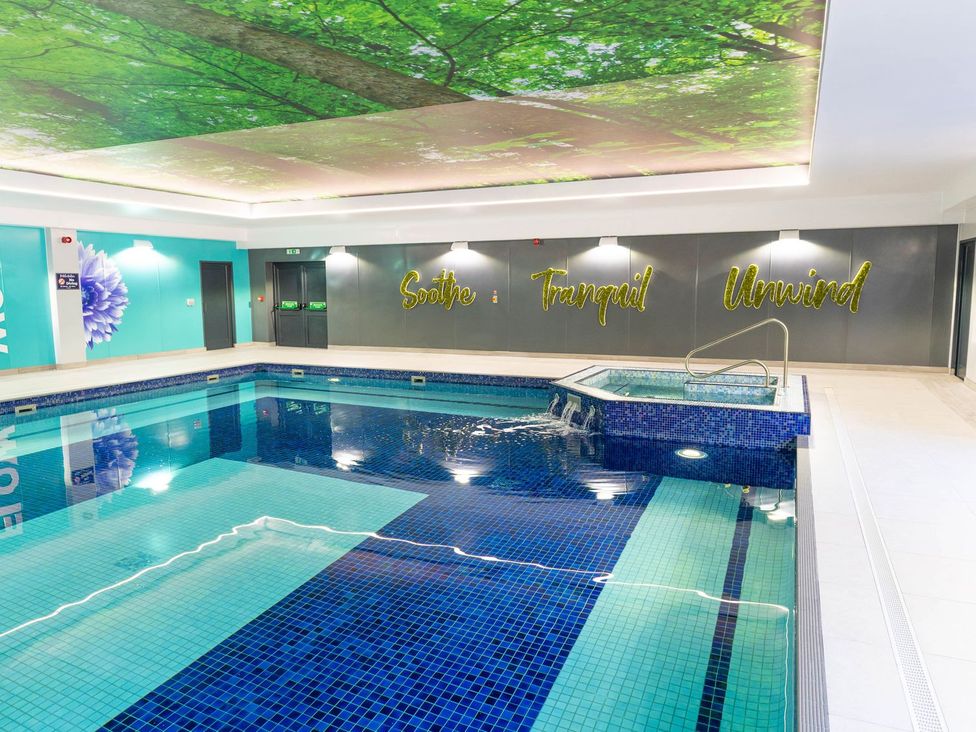 An indoor pool with a jacuzzi at Mayfly Lodge St Tudy