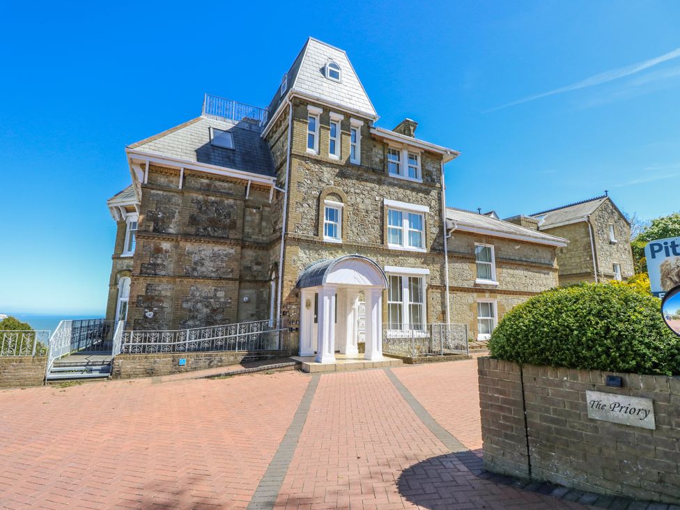 An exterior view of a large building with a driveway at The Priory in Shanklin