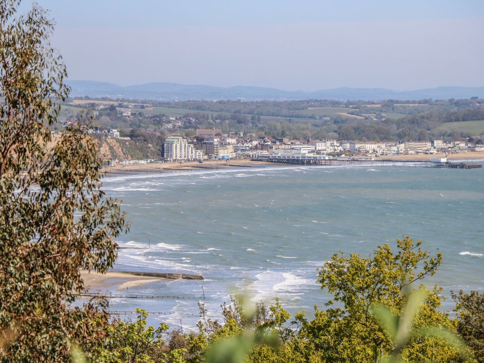 A view of seaside buildings and pier from a hillside at 6 Priory in Shanklin