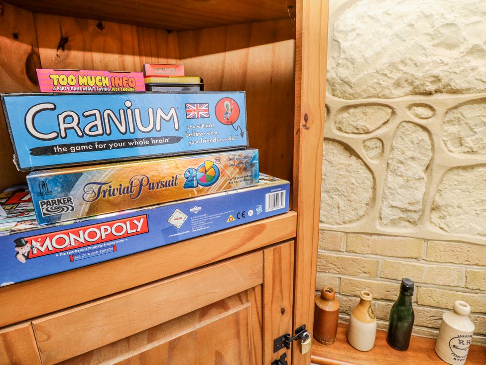 A shelf with board games and bottles at 6 Priory Shanklin