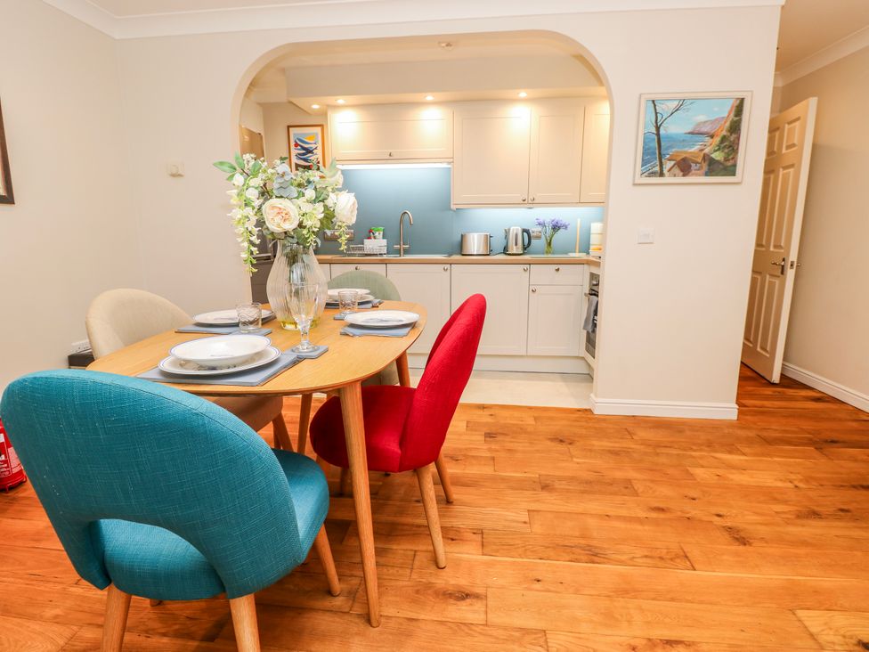 A kitchen with a dining table and chairs at 6 Priory in Shanklin