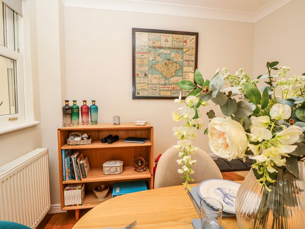 A dining room with a table and flowers at 6 Priory Shanklin